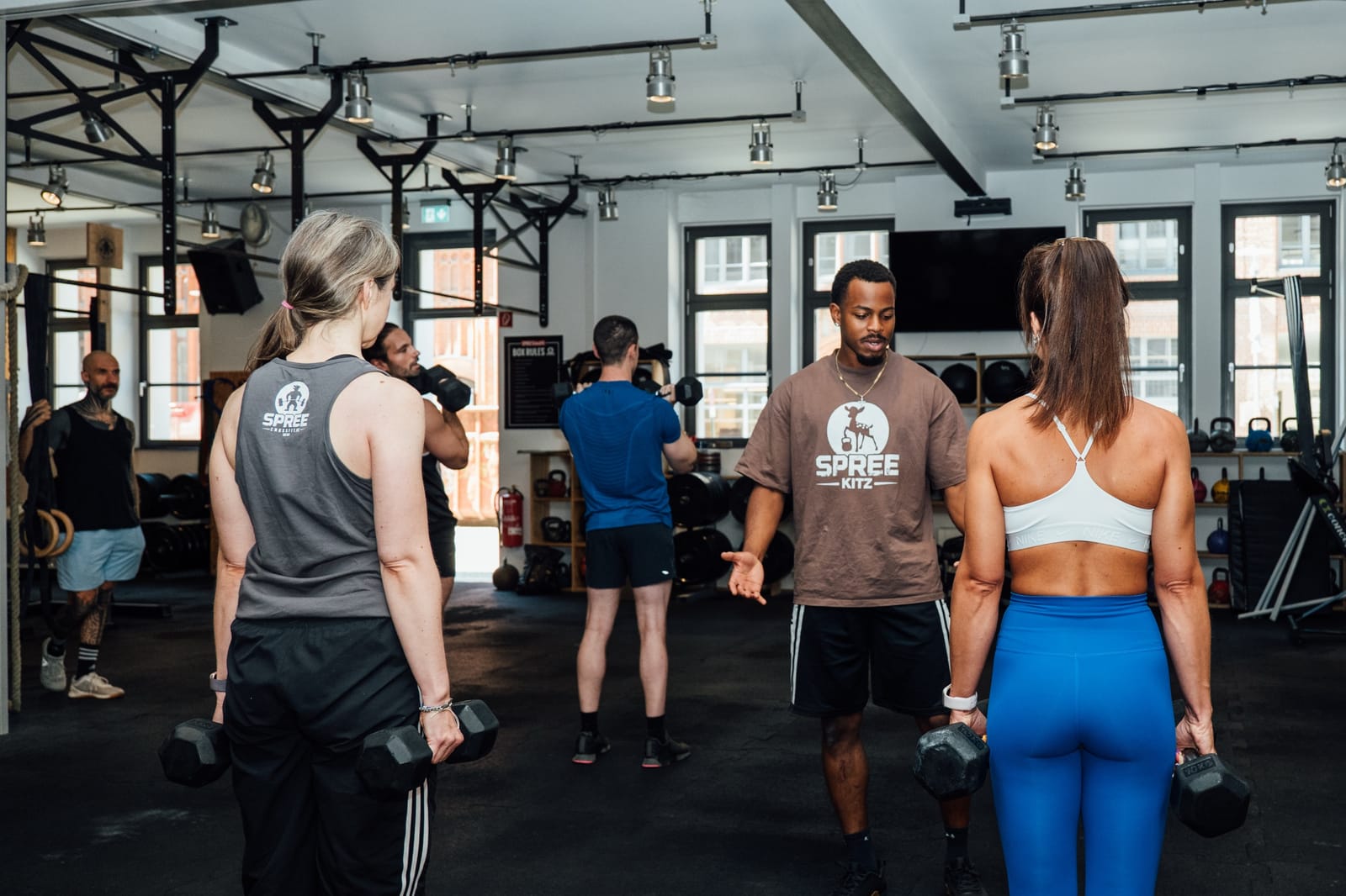 Isaac Akinsete coaching a small group with dumbbells at SPREE Intense Fitness, Berlin-Friedrichshain